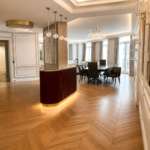Salon d'un appartement de prestige à Nice rénové par Aktive : parquet point de Hongrie, moulures, meuble bar cannelé bordeaux