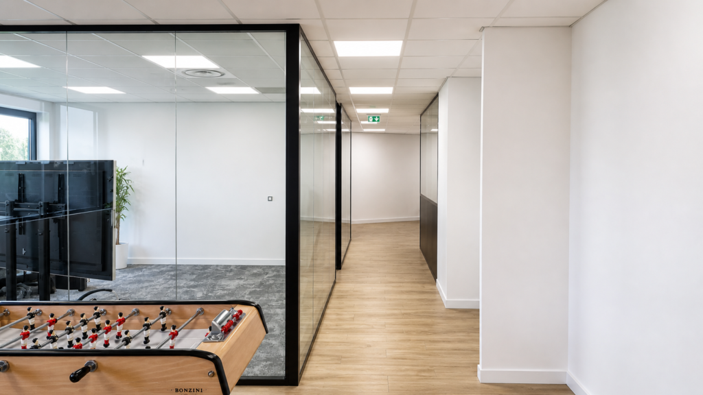 Salle de réunion vitrée et circulation en parquet, bureaux aménagés par Aktive à Cannes