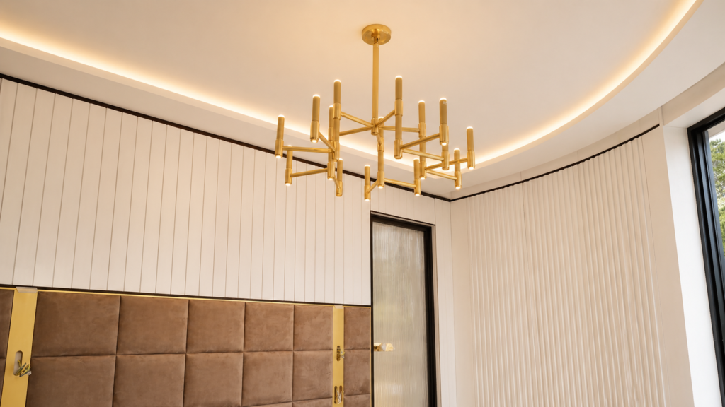 Chambre réalisée par Aktive à Grasse : lustre en laiton, tête de lit capitonnée, lambris cannelé et corniche lumineuse